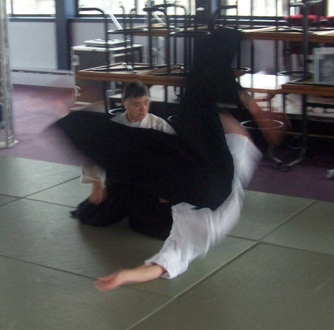 An aikidoka, upside down during a flying mae ukemi